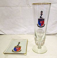 Champagne flute and glass ash tray with printed RMC crest and gold rim on glass