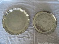 Both plates side by side, showing scalloped and rope-edge rims and engraved centers