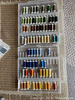 Top view of Slimline Storage Box opened showing multiple compartments filled with various colored Sulky thread spools.