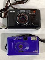 Front view of Canon AF35M camera showing autofocus and flash features along with Fun Shooter purple focus-free camera