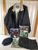 Full lot of golf apparel on display including jacket, pants, mittens in package, hat, and shirts.