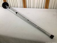 Full view of the silver telescoping arm with black end caps and base showing the full length and design of the golf bag support arm.