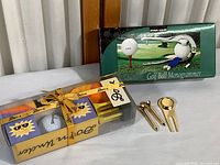 Spaulding golf balls set and Star Case Golf Ball Monogrammer in original box together on surface.