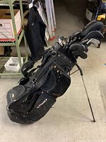 Black Ogio stand bag with folding legs and strap in basement setting