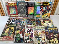 Overview of 16 Marvel comic books showing mostly Spider-Man series, Excalibur series, and Fantastic Four. Comics in plastic sleeves, some with clear windows, arranged on white surface.