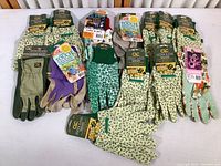 Wide view showing all fourteen pairs of gardening gloves laid out flat, with visible tags