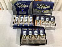 Overall display of all boxes and sleeves of Titleist golf balls, showing unopened packages and branding.