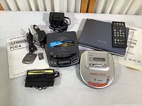 Lot with Pioneer portable DVD player and remote, Fisher PCD-6 CD player with car adapter and headphones, Aiwa Video CD player and manuals