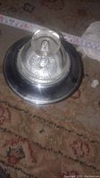 Top view of the lid with rounded transparent handle, measuring tape showing size