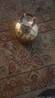 Top angle view of the antique kerosene stove on a patterned carpet.