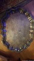Top view of silver-plated serving tray showing scalloped edges and tarnished surface