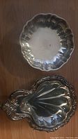 Top view of round silver plated dish with scalloped edges and some tarnishing.
