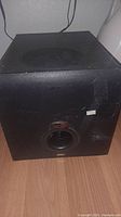 Front view of Klipsch AMP120 subwoofer showing speaker port and cabinet condition.