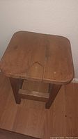 Top and angled side view of rectangular wooden side table with three plank top and lower shelf.