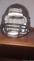 Front view of black Riddell football helmet showing faceguard and interior padding