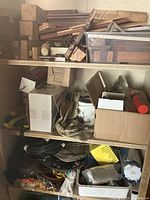 Wood pieces of different shapes and sizes on upper shelf including blocks and planks with natural and sanded finishes along with pinecones and miscellaneous small items.