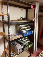 Full view of black metal frame shelving unit with four shelves containing various items (not included).