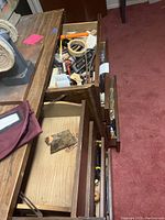 Top view of the dresser with open drawers showing various tools, hardware, and miscellaneous items inside drawers.