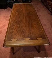 Top view showing walnut veneer grain pattern and dovetail inlays at ends