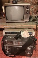 Full view of the vintage Sylvania TV on top, the Rhapsody radio with cassette player behind, and the Sound Design radio and cassette recorder with microphone and strap in front.