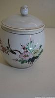 Angle showing floral hand-painted design with birds.