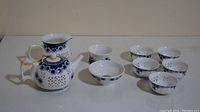 Full set arranged on a table showing 1 teapot, 1 pitcher, 7 cups