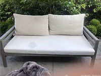Full front view of sofa with cushions and visible water stain on left seat cushion