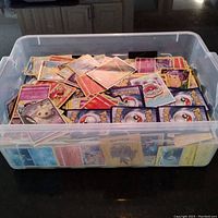 Clear plastic tub filled with assorted Pokémon cards, top view