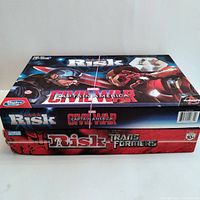 Stacked boxed Marvel Captain America and Transformers Risk board games showing front and side box artwork.