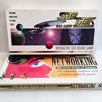Photo showing two vintage board games: Star Trek The Next Generation VCR board game and Networking board game stacked side by side.