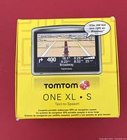 Box of TomTom ONE XL·S GPS navigation system in bright yellow color with image of GPS screen showing map and directions on the front.
