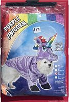 Sealed plastic bag containing a purple unicorn pet costume designed for small to medium-sized pets. Packaging shows a dog wearing the costume with rainbow horn and the text 'Purple Unicorn'. Size Medium indicated, fitting pets 11-15 lbs.