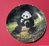 Front image of the wall plate showing the detailed painted scene of a mother panda with a baby panda in a natural setting with bamboo.