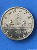 Obverse side of the 1956 Canadian silver dollar coin showing the voyageurs and the year 1956.