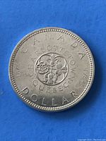 Reverse side of the 1964 Canadian Charlottetown Silver Dollar Coin featuring floral emblems and commemorating the Charlottetown Conference with dates indicated.