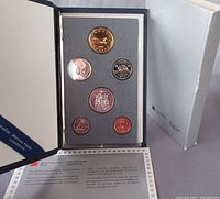 Front view of the 1988 Canadian Specimen Coin Set displayed in black presentation folder with six coins visible in protective plastic holder, certificate partially visible, outer white sleeve to the right.