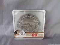 Front view of sealed commemorative set showing embossed medallion with soldier profile, 60th VE Day text and coin featuring King George VI portrait.