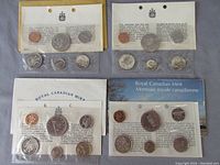 Four sealed Canadian coin sets from 1970 to 1973 with certificates and packaging.