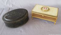 Photo showing both the oval embossed metal box and rectangular cream lattice jewelry box side by side