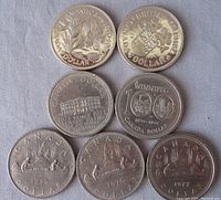 Seven Canadian one dollar coins from 1970 to 1977 dated, each with unique provincial or commemorative designs, displayed on a cloth background.