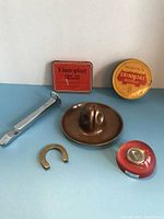 Overview photo showing all the miscellaneous collectibles including tins, horseshoe, copper Stetson hat and railway spike bottle opener.