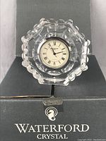 Front view of Waterford crystal clock with Roman numeral face inside original box.