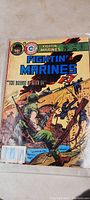 Full cover view of Fightin' Marines comic book showing illustrated wartime action with Marines fighting on a bridge, featuring vivid colors and price of 75 cents.