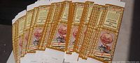 Front view of multiple vintage Cinci Cream beer advertisement fold-up cards arranged in a fan-like display, showing gold and cream decorative borders and the illustrated waiter character.
