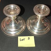 Pair of Birks sterling silver plate candlesticks shown from above and side profile.