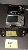 Top view of three digital cameras showing screens and rear controls.
