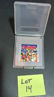 Dr. Mario game cartridge placed inside open translucent plastic protective case on black background, with yellow sticky note labeled 'Lot 14'.