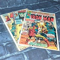 Five Iron Man comic books stacked and displayed