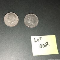 Obverse side of two Kennedy half dollars dated 1972 and 1974 showing John F. Kennedy profile with no visible mint marks