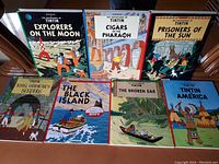 Full set of seven Tintin comics displayed on a table.